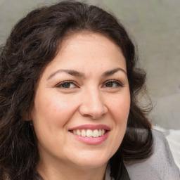 Joyful white adult female with medium  brown hair and brown eyes