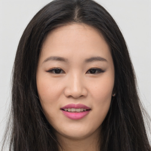Joyful asian young-adult female with long  brown hair and brown eyes