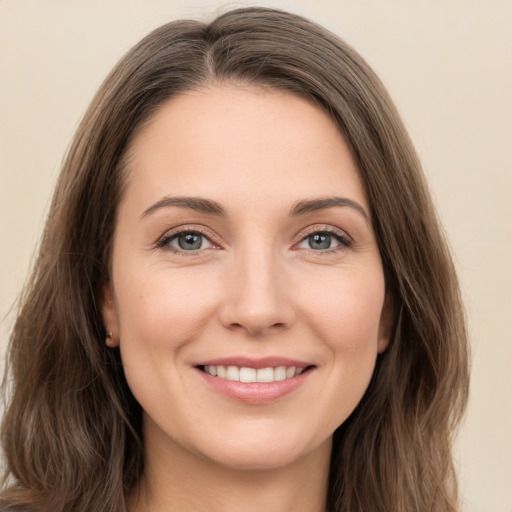 Joyful white young-adult female with long  brown hair and green eyes