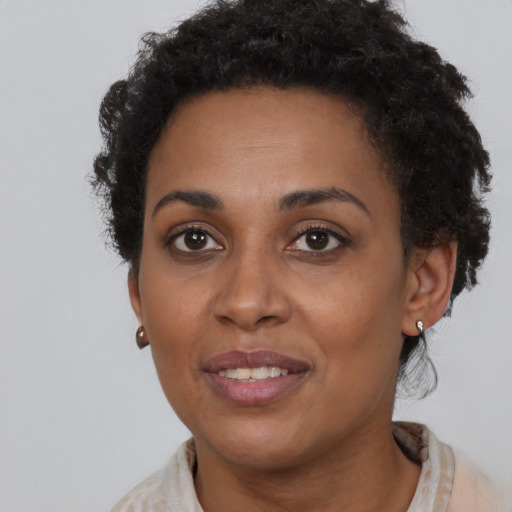 Joyful black young-adult female with short  brown hair and brown eyes