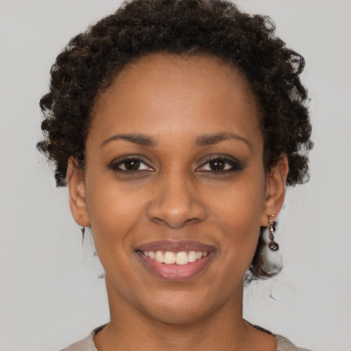 Joyful black young-adult female with short  brown hair and brown eyes
