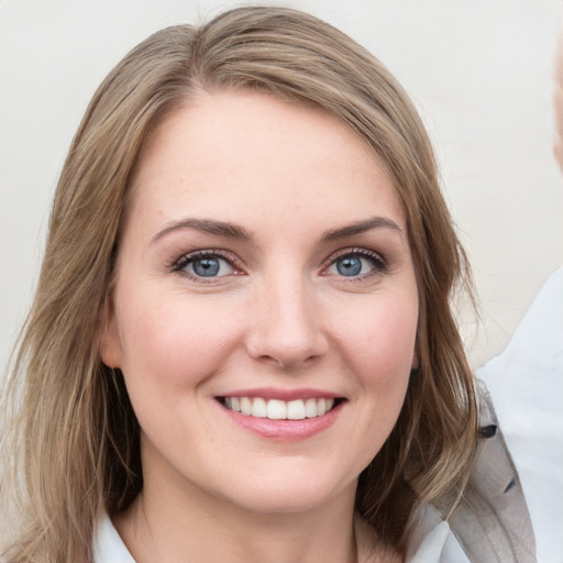 Joyful white young-adult female with medium  brown hair and blue eyes