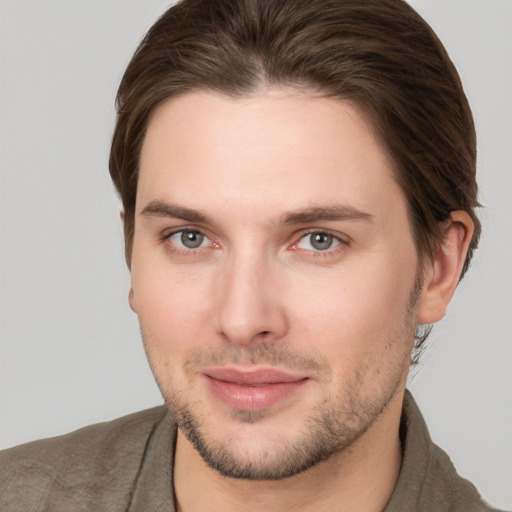 Joyful white young-adult male with short  brown hair and grey eyes