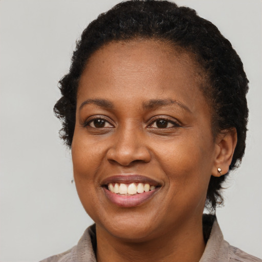 Joyful black adult female with short  brown hair and brown eyes