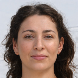 Joyful white adult female with long  brown hair and brown eyes