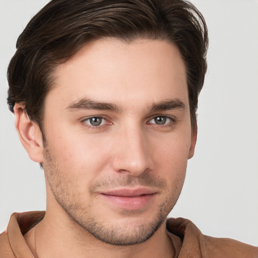 Joyful white young-adult male with short  brown hair and grey eyes