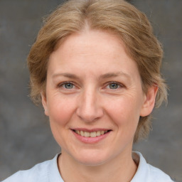 Joyful white adult female with medium  brown hair and blue eyes