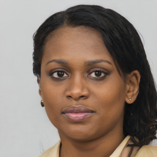 Joyful black young-adult female with long  black hair and brown eyes