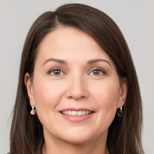 Joyful white adult female with long  brown hair and grey eyes