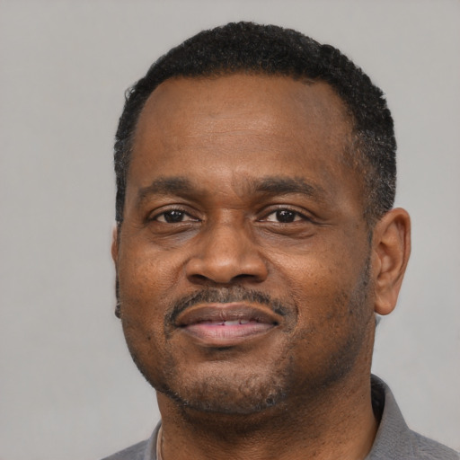 Joyful black adult male with short  black hair and brown eyes