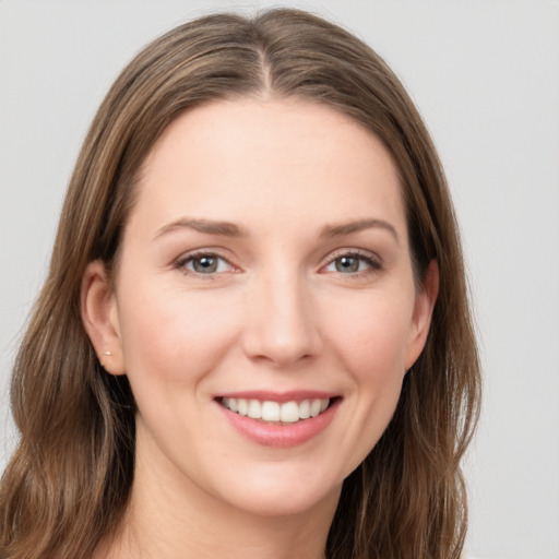 Joyful white young-adult female with long  brown hair and grey eyes