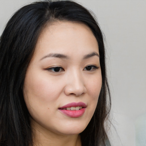 Joyful asian young-adult female with long  brown hair and brown eyes