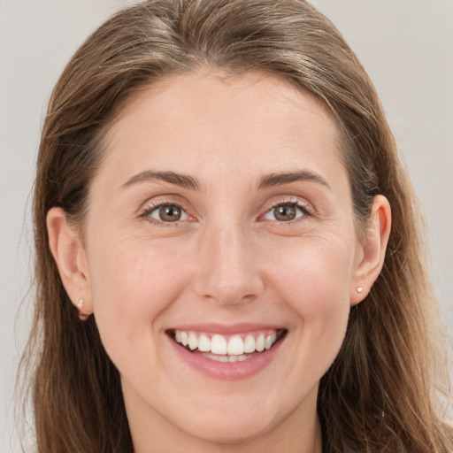 Joyful white young-adult female with long  brown hair and blue eyes