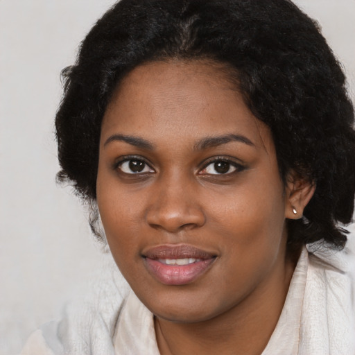 Joyful black young-adult female with medium  black hair and brown eyes