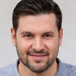 Joyful white adult male with short  brown hair and brown eyes