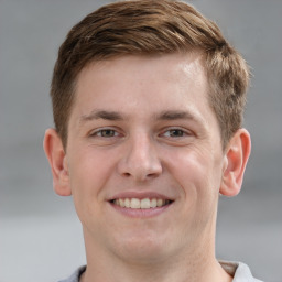 Joyful white young-adult male with short  brown hair and grey eyes