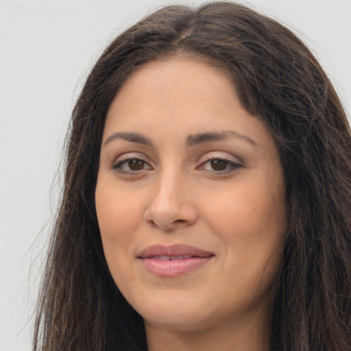 Joyful latino young-adult female with long  brown hair and brown eyes