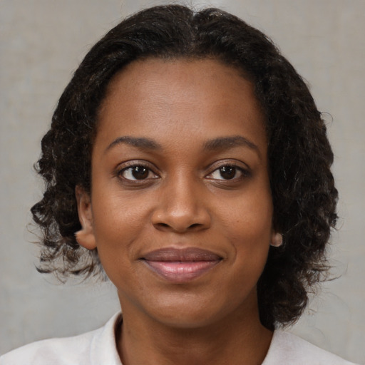 Joyful black young-adult female with medium  black hair and brown eyes
