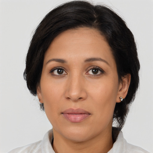 Joyful latino adult female with medium  brown hair and brown eyes