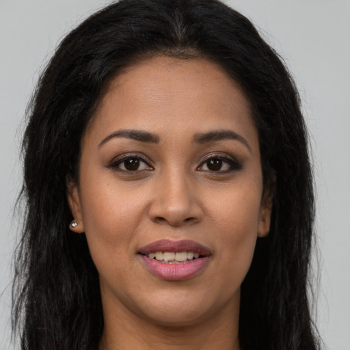 Joyful latino young-adult female with long  brown hair and brown eyes