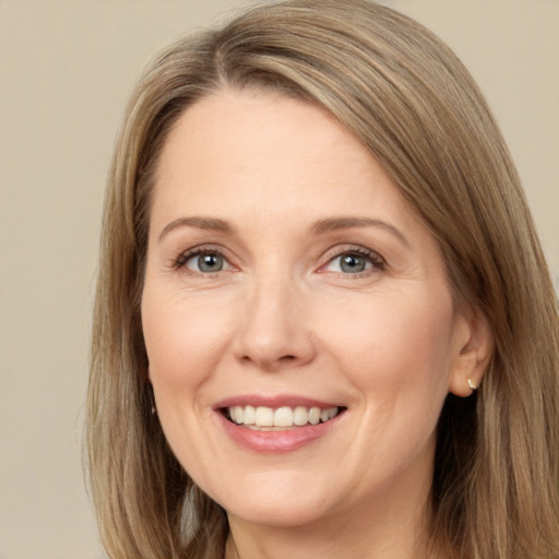 Joyful white adult female with long  brown hair and grey eyes