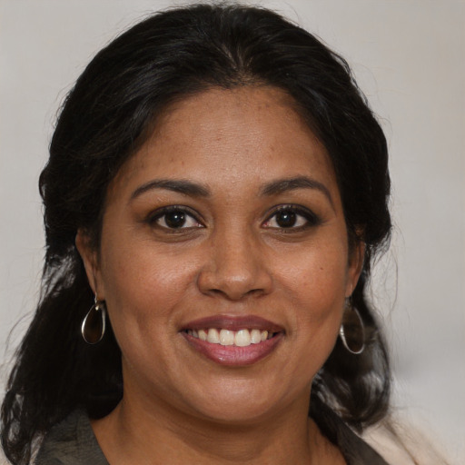 Joyful black adult female with medium  brown hair and brown eyes
