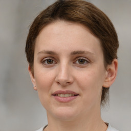 Joyful white young-adult female with medium  brown hair and grey eyes