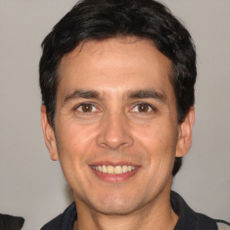 Joyful white adult male with short  black hair and brown eyes