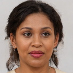 Joyful latino adult female with medium  brown hair and brown eyes