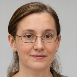 Joyful white adult female with medium  brown hair and grey eyes