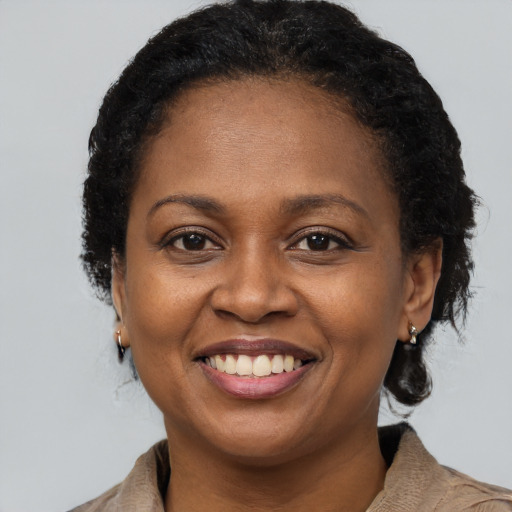 Joyful black adult female with short  brown hair and brown eyes