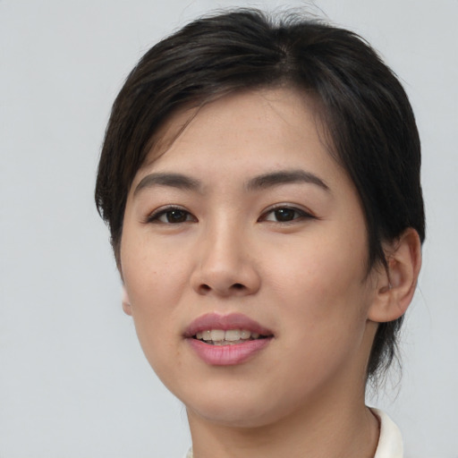 Joyful asian young-adult female with short  brown hair and brown eyes