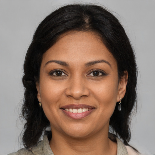 Joyful black young-adult female with medium  brown hair and brown eyes