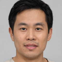 Joyful asian young-adult male with short  black hair and brown eyes