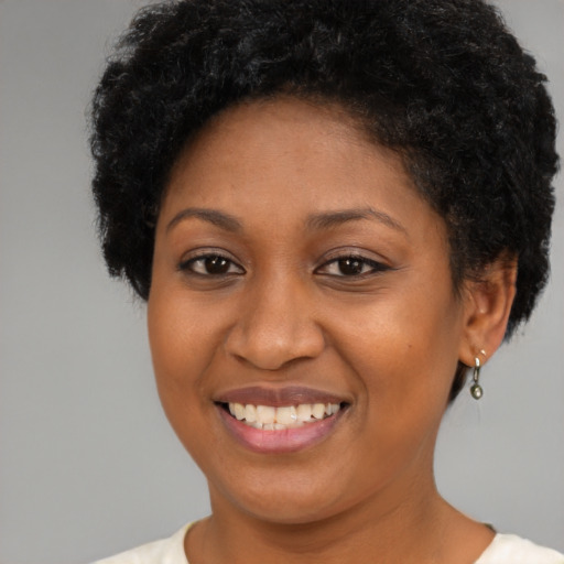 Joyful black young-adult female with short  brown hair and brown eyes