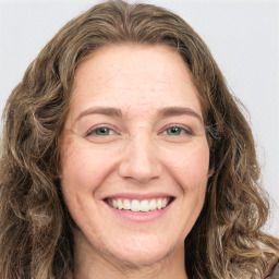 Joyful white adult female with long  brown hair and green eyes