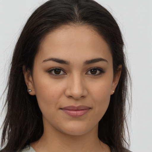 Joyful latino young-adult female with long  brown hair and brown eyes