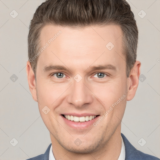 Joyful white young-adult male with short  brown hair and grey eyes