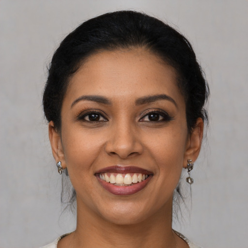 Joyful latino young-adult female with medium  brown hair and brown eyes