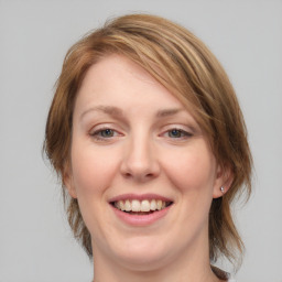 Joyful white young-adult female with medium  brown hair and green eyes