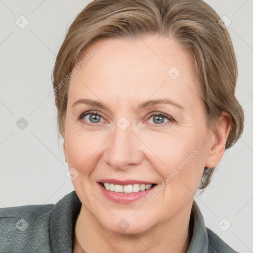 Joyful white adult female with medium  brown hair and grey eyes