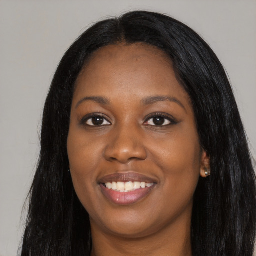 Joyful black young-adult female with long  black hair and brown eyes