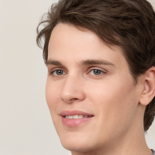 Joyful white young-adult male with medium  brown hair and grey eyes