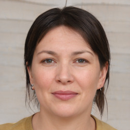 Joyful white adult female with medium  brown hair and grey eyes