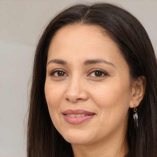 Joyful white adult female with long  brown hair and brown eyes
