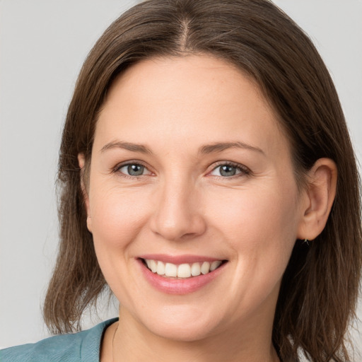 Joyful white young-adult female with long  brown hair and grey eyes