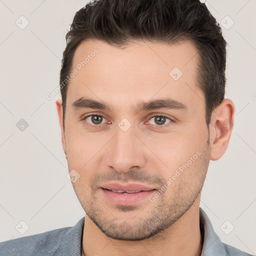 Joyful white young-adult male with short  brown hair and brown eyes