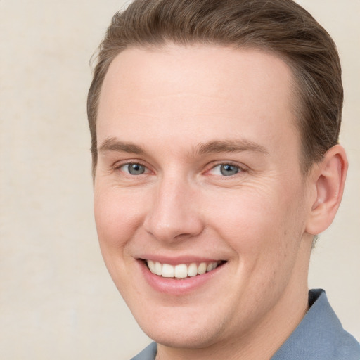 Joyful white young-adult male with short  brown hair and grey eyes