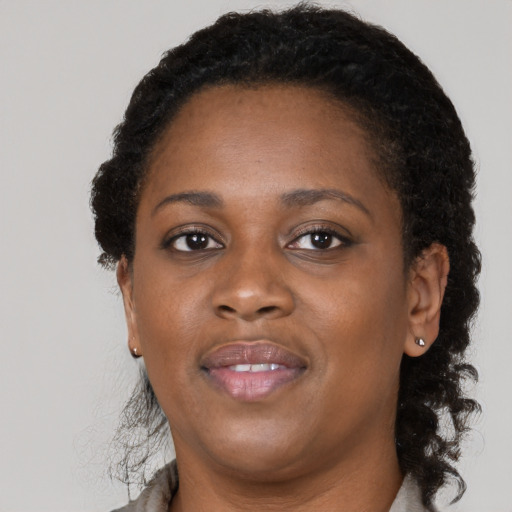 Joyful black adult female with medium  brown hair and brown eyes