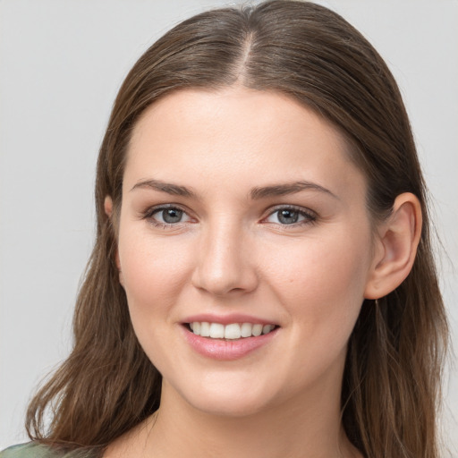 Joyful white young-adult female with long  brown hair and grey eyes